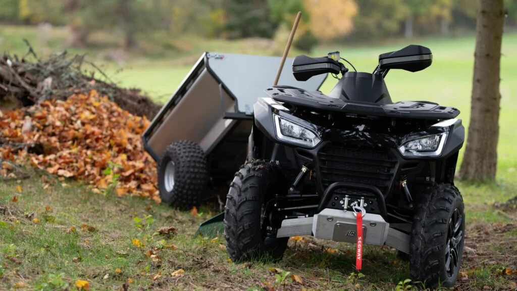 Segway Snarler ATV med släpvagn vid en skogsbryn.